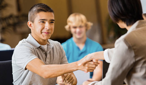 student and teacher business shaking hands